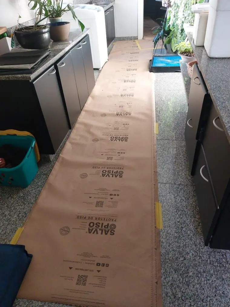 Proteção de piso instalada ao longo de todo o trajeto de circulação dentro de um apartamento habitado.