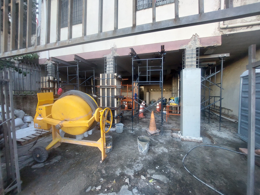 Canteiro de obra organizado, com materiais e ferramentas dispostos de forma padronizada.