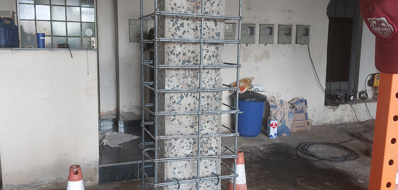 Pilar de concreto com armadura de reforço montada, preparado para encamisamento.